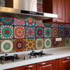 A kitchen backsplash featuring colorful mandala peel and stick tiles on a brown cabinet and stainless steel countertop.