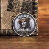 A silvery commemorative faith cross coin featuring a depiction of Jesus with a crown of thorns.