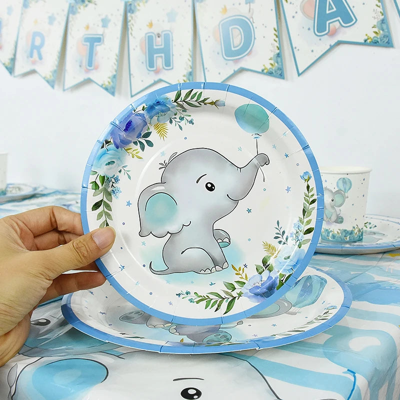 A blue and white cartoon elephant disposable party tableware set on a light blue tablecloth.