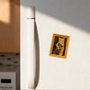 A vintage framed photo of a cat hugging another cat is displayed on a white refrigerator.