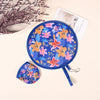 A blue fabric cooling fan with a floral pattern is shown next to a small folded version and a card.