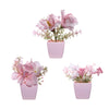 A pink flowering plant in a square pot used for home decor.