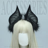 A pair of black bat simulation ears made of faux fur attached to a blonde wig display.