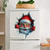 A refrigerator features a festive Christmas Santa face cutout decal on the door, with greenery in a wooden planter above.
