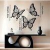 Black metal butterfly wall decor featuring various sizes and dimensions displayed above a black table.