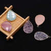 A collection of five polished gemstone pendants, including blue-green and pink agate, displayed on a wooden tray.