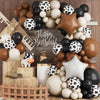A balloon arch kit featuring various brown, white, and black polka-dot balloons arranged in a rustic farm theme display.