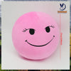 A pink, round plush doll with a smiling face and black eyes, used as a stress relief pillow.