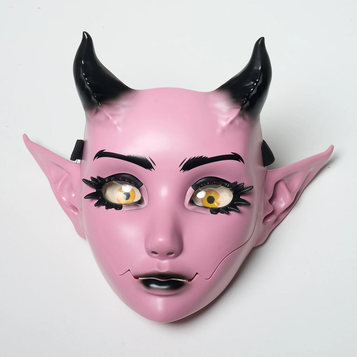 A pink fantasy creature mask with black horns and detailed eye makeup.