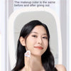 A woman looking into a vanity mirror while holding a white LED mirror accessory.