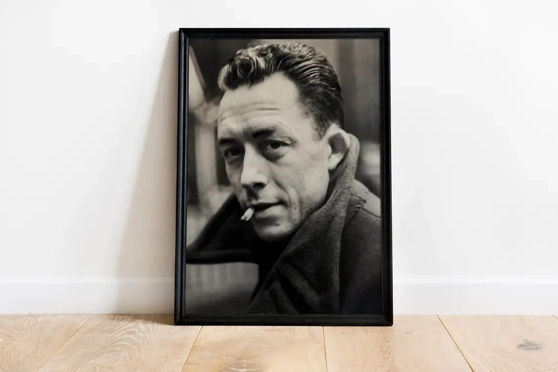 Black and white portrait photograph of a man with slicked-back hair and a beard, displayed in a black frame.