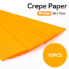 A stack of orange crepe paper sheets, measuring 50 x 75cm, is shown in a close-up view.