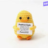 A yellow knitted plush duck with a tag that reads Positive Duck I may be a tiny duck but I believe in you Go do your thing Yo