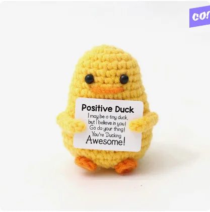 A yellow knitted plush duck with a tag that reads Positive Duck I may be a tiny duck but I believe in you Go do your thing Yo