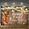 A rustic wooden barn door backdrop featuring cowboy boots and string lights for a birthday theme.