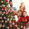 A woman and a child decorate a Christmas tree with red and white candy cane ornaments.