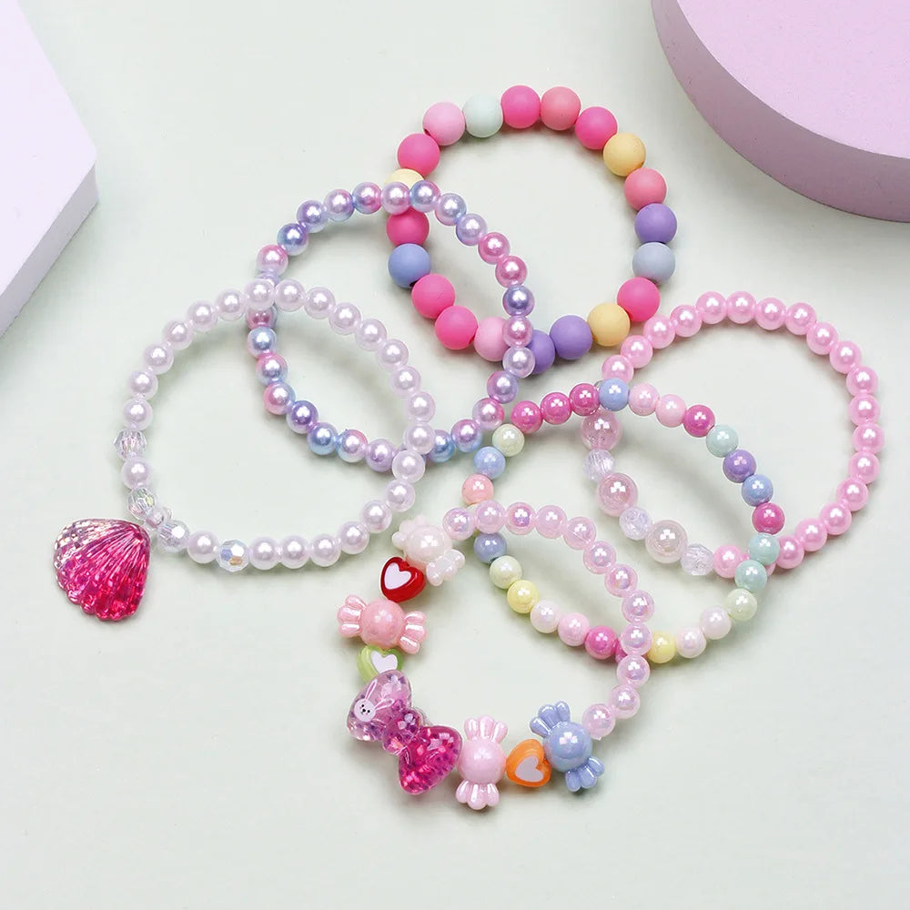 A set of six beaded bracelets featuring various shades of pink, purple, and white beads.