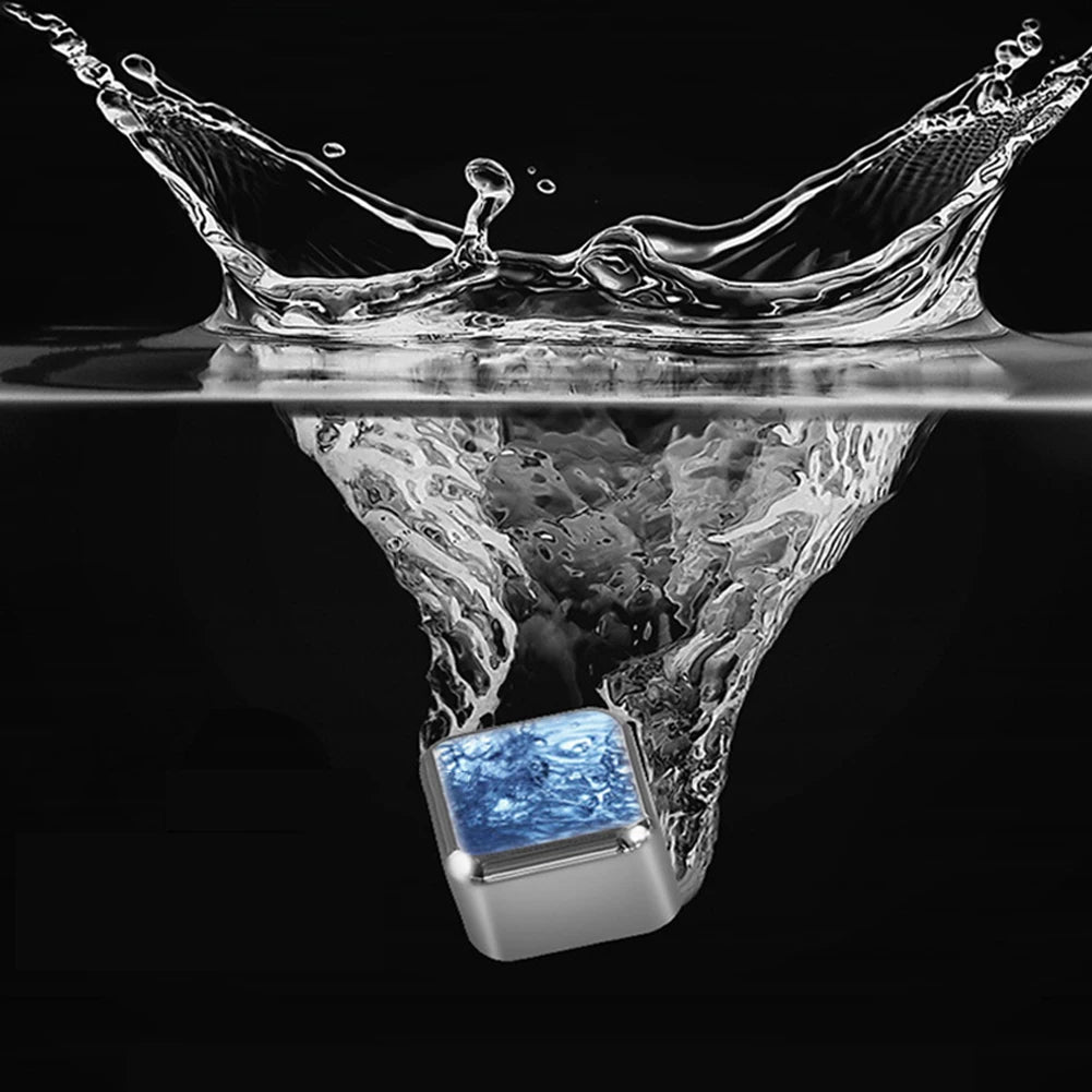 A close-up shot of a stainless steel ice cube dropping into water, creating a splash and reflection.