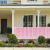 A pink artificial cherry blossom privacy fence screen in front of a light-colored house.