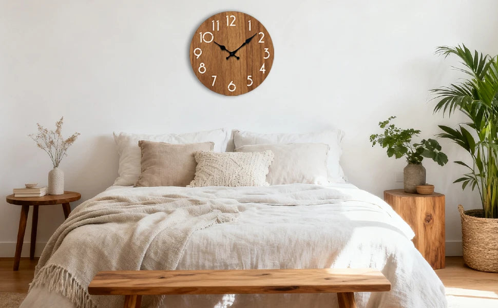 A bedroom scene featuring a minimalist wooden wall clock above a bed with white linens and natural wood furniture.