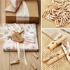 A collection of wooden mini clothespins in various natural wood tones and sizes for crafts and photo displays.