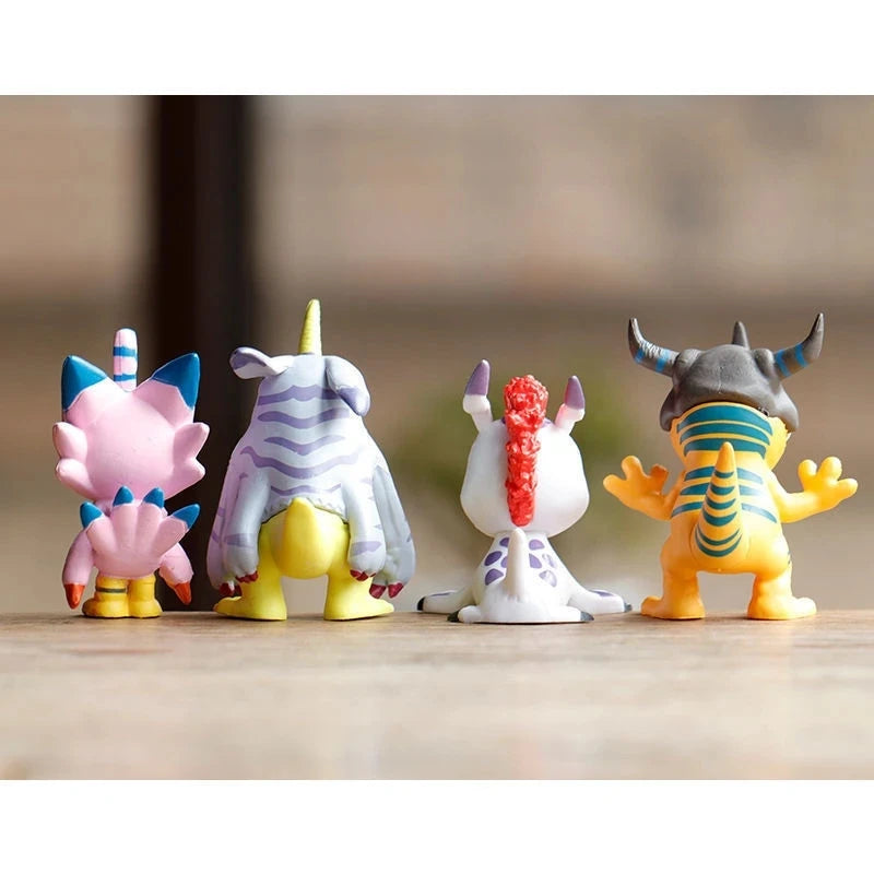 A set of four Digimon Adventure 9-Figure collectible figures standing on a wooden surface.