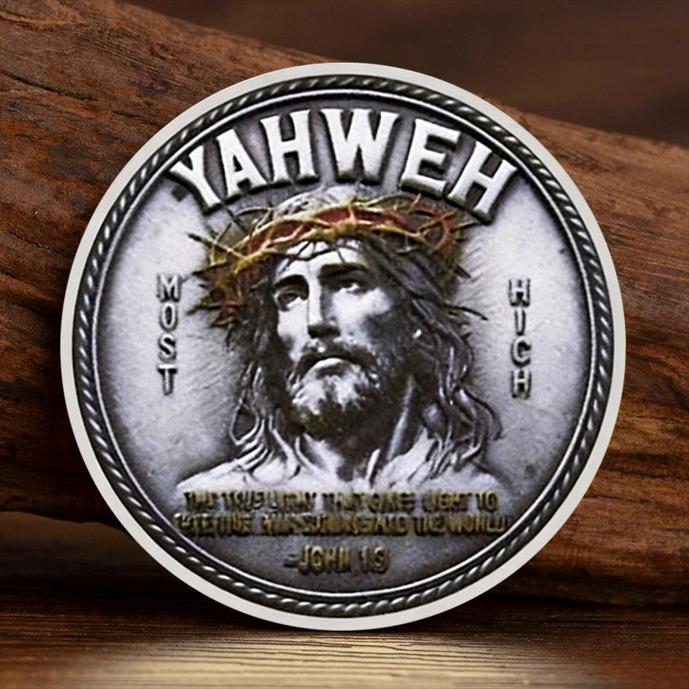 A silver commemorative coin featuring a depiction of Jesus Christ with a crown of thorns and the inscription Yahweh.
