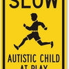 A yellow sign with black text that reads SLOW AUTISTIC CHILD AT PLAY