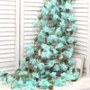 A cascading garland of artificial light blue sakura flowers draped against a white slatted background.