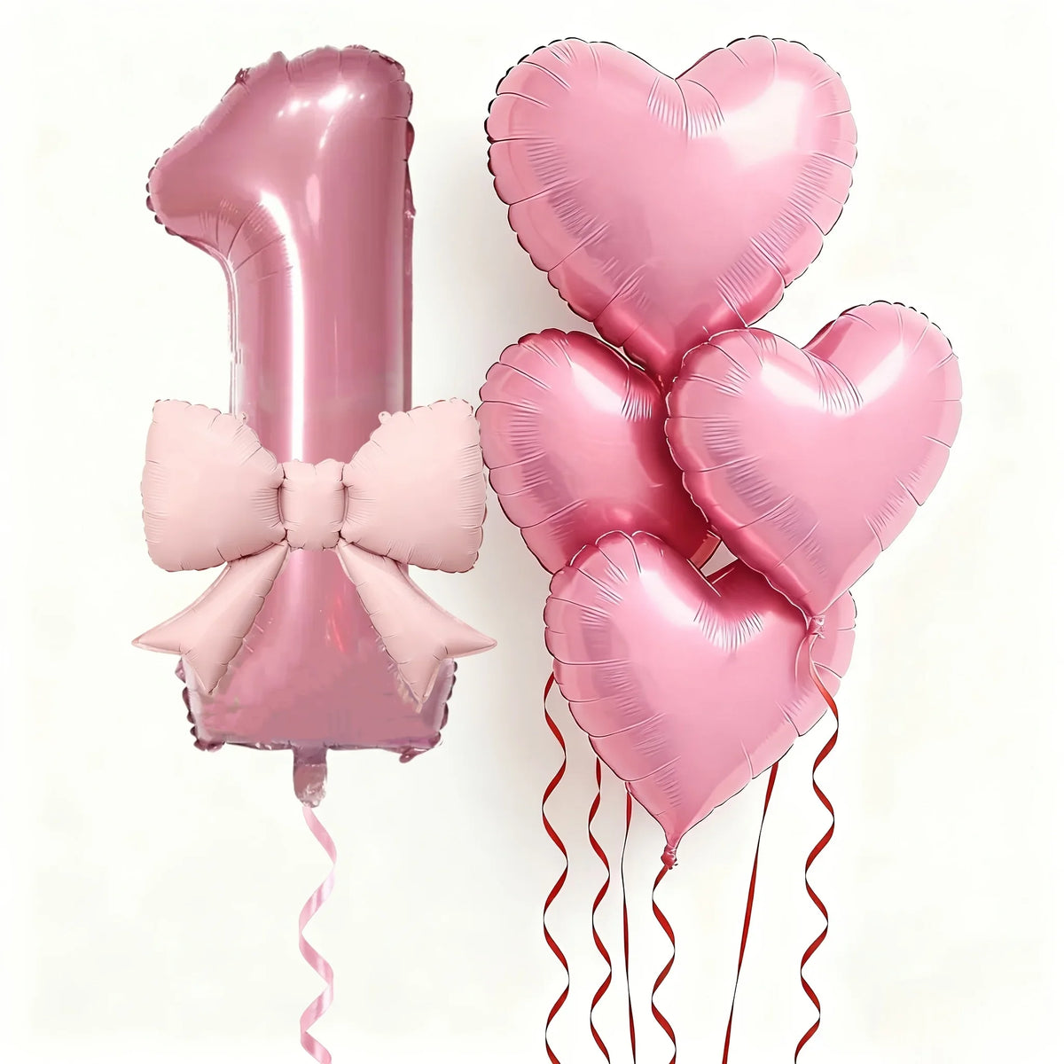 Pink foil balloons shaped like the number one and heart for party decoration