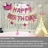 A silver tinsel foil fringe curtain backdrop decorated with pink balloons and a birthday banner for a party.