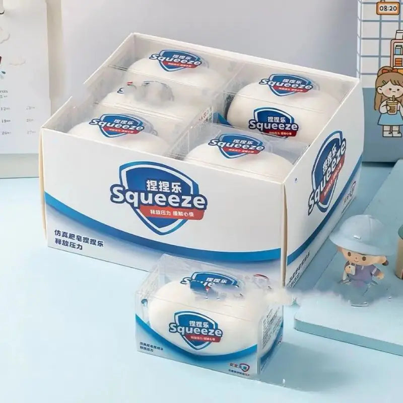 A box of Squeeze toys featuring white cat paw shaped squishies and a loose squishy toy.