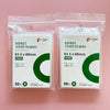 Two sealed packages of POPCORN Games premium card sleeves, 63.5 x 88mm, with green card sleeves visible.