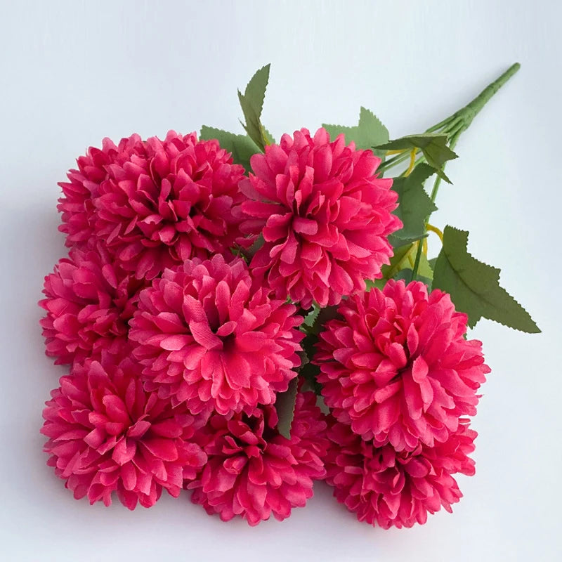 A bouquet of artificial hydrangea and camellia flowers in vibrant pink and magenta tones.