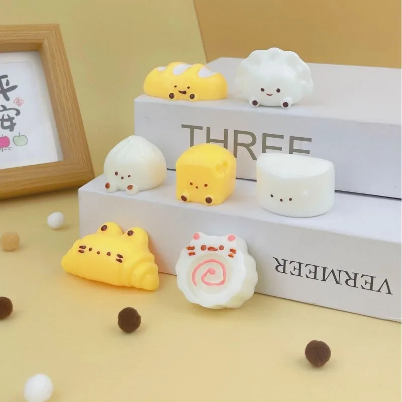 A collection of white and yellow cute cartoon food squeeze toys arranged on a white box.