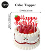 A cake topper featuring a strawberry and the words Happy Birthday on a white cake.