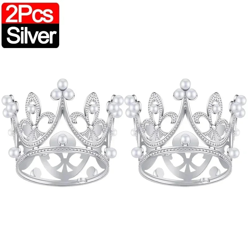 A pair of silver crown cake topper decorations.