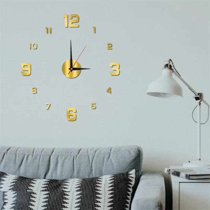 A round gold-colored acrylic digital wall clock with numbers and hands mounted on a light gray wall.