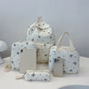A set of white fabric backpacks and matching accessories featuring a black bow print pattern.