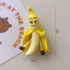 A yellow banana fruit fridge magnet with a smiling face and a white toothy grin.