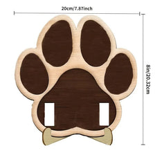 A wooden paw print cutout used as a frame for a photo, featuring a dark brown color.