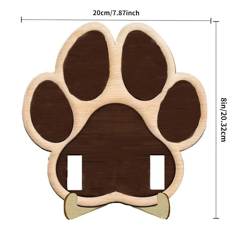 A wooden paw print cutout used as a frame for a photo, featuring a dark brown color.