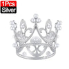 A silver crown cake topper decoration featuring intricate metalwork and pearl-like accents.
