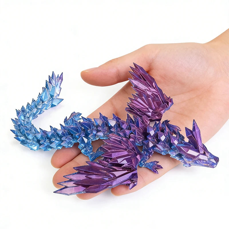 A hand holds a purple and blue 3D printed magic dragon ornament made of crystals.