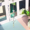 A crystal moon and sun wind chime decor set featuring various hanging crystals displayed in a white frame.