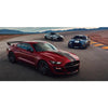 A red Ford Mustang Shelby GT driving on an open road with other cars in the background.