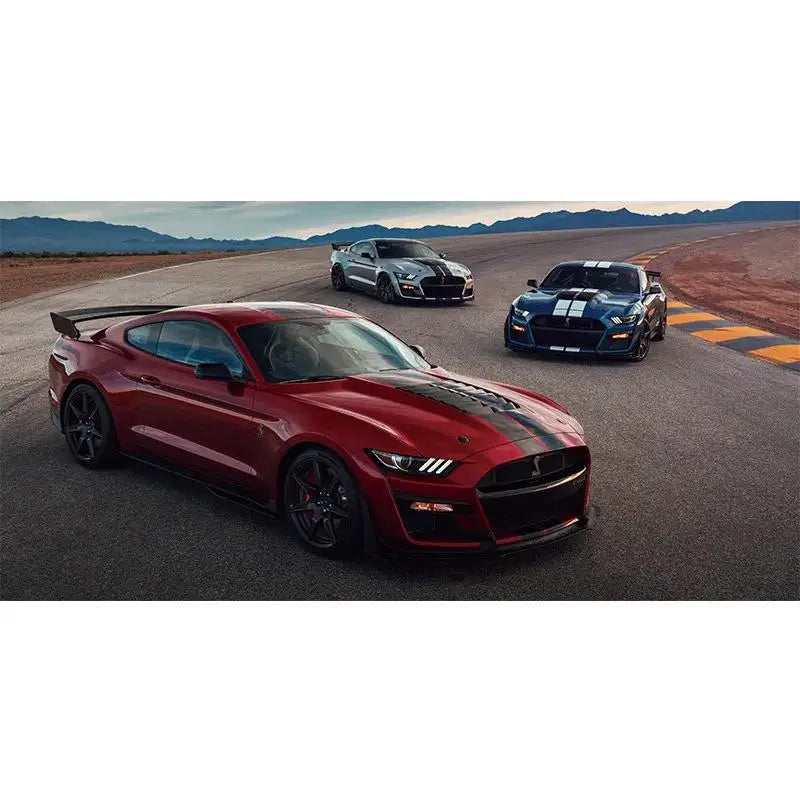 A red Ford Mustang Shelby GT driving on an open road with other cars in the background.