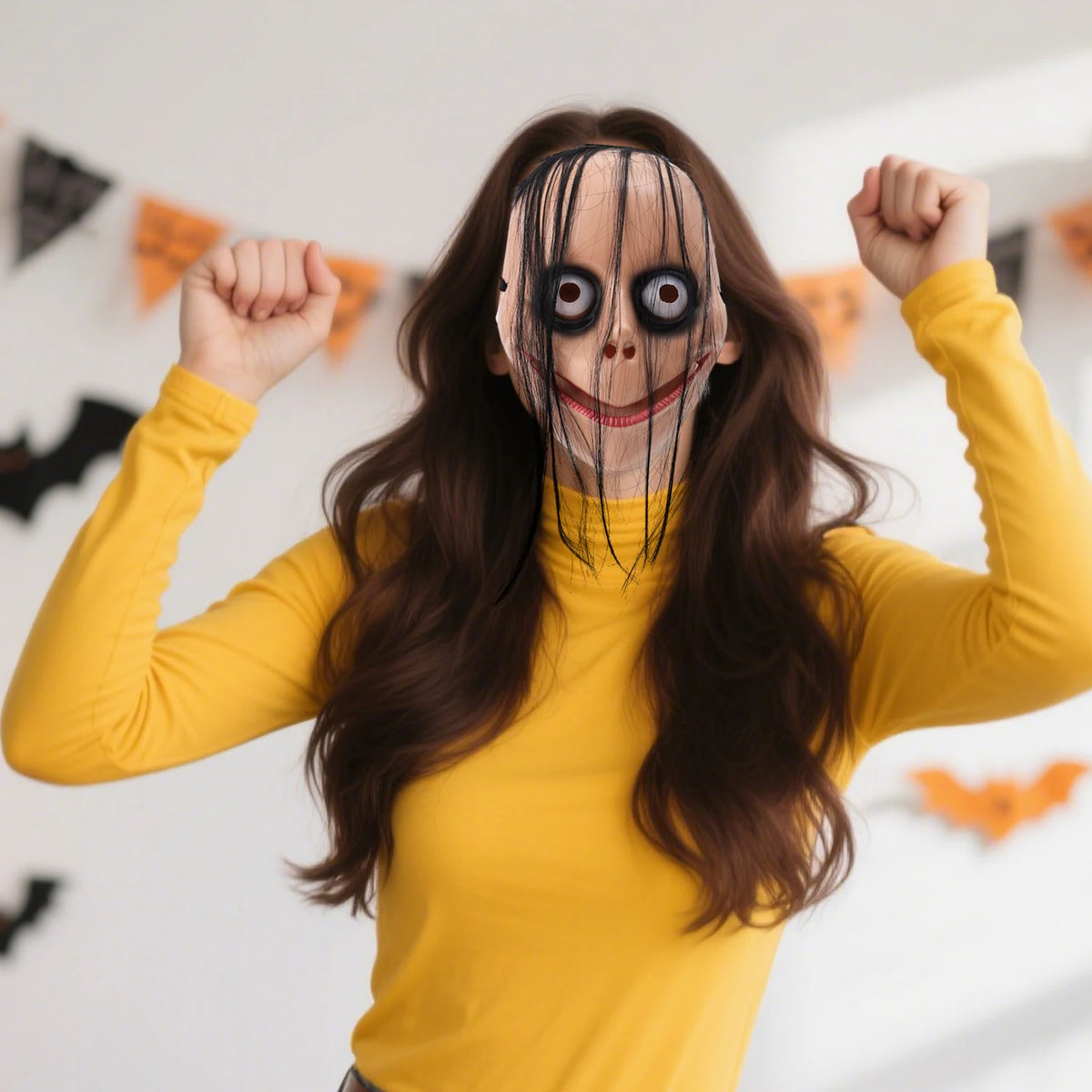 A woman wearing a full face horror costume mask resembling a creepy clown with exaggerated features and dark makeup.