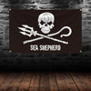 A black banner featuring a white skull and crossbones design with a pirate sword and the text SEA SHEPHERD.