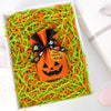Orange Halloween crinkle paper shred filler for treat bags and décor with a pumpkin-shaped tag